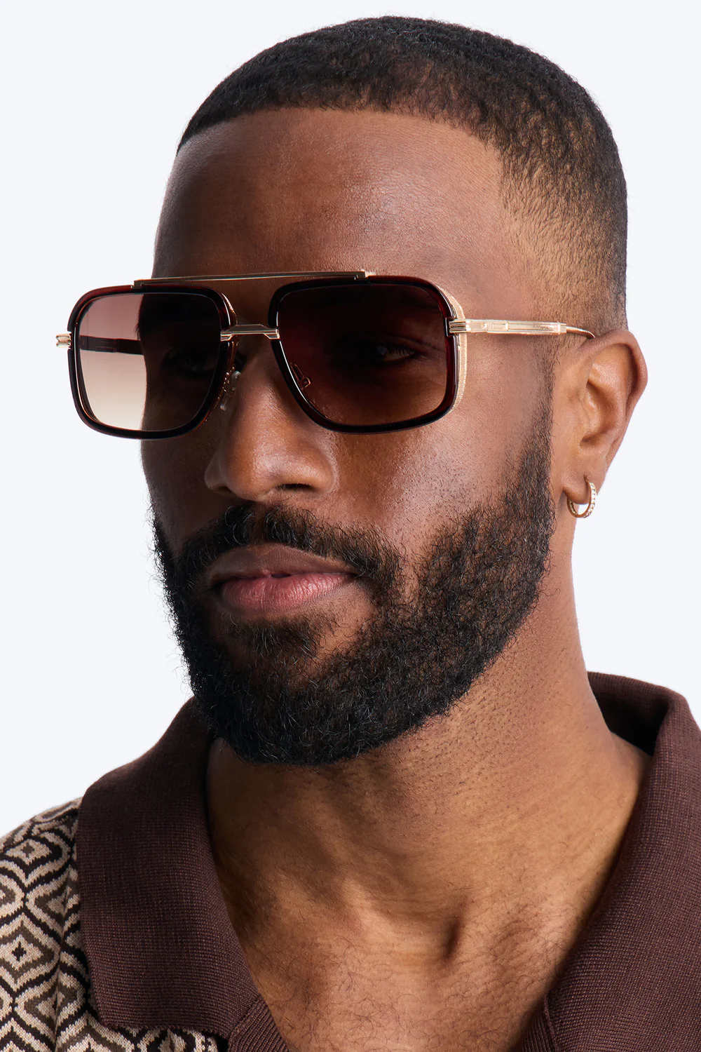 Polo marron geometrico con gafas premium